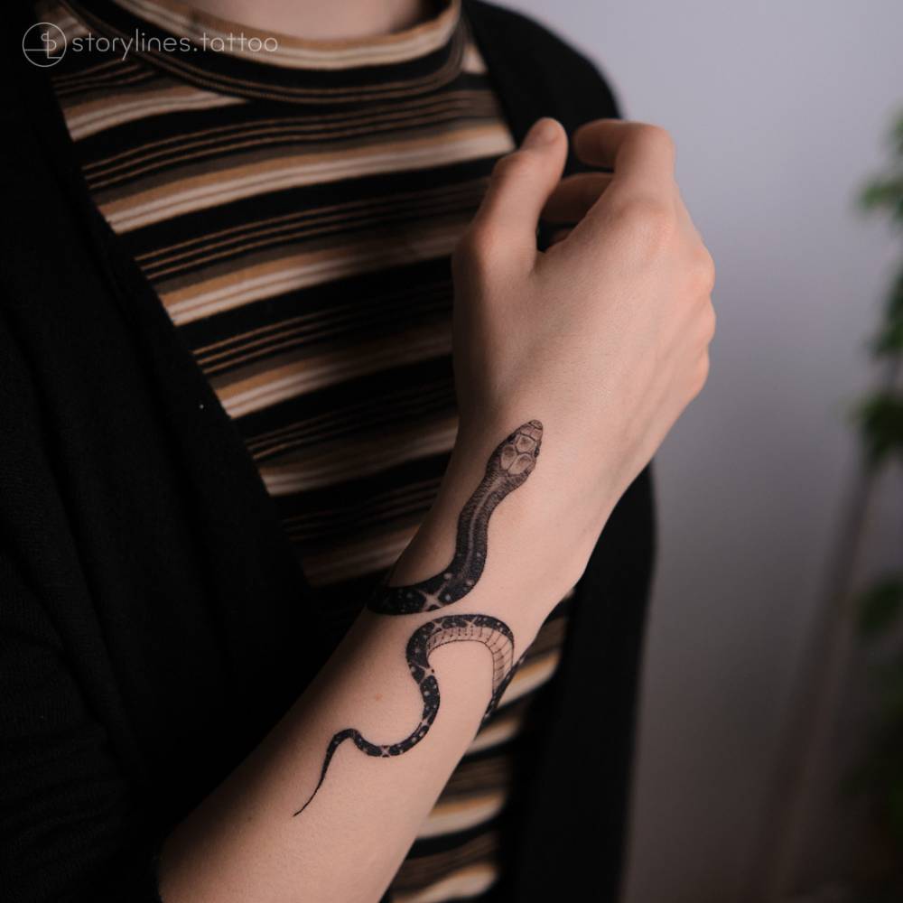 Traditional style snake tattoo on the left wrist